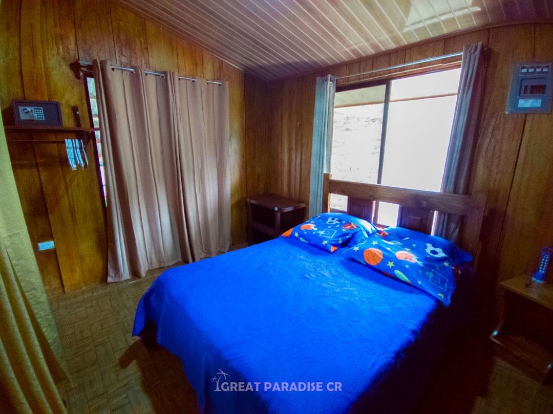 Dormitorio con cama azul y ventanas en Villa Fonseca