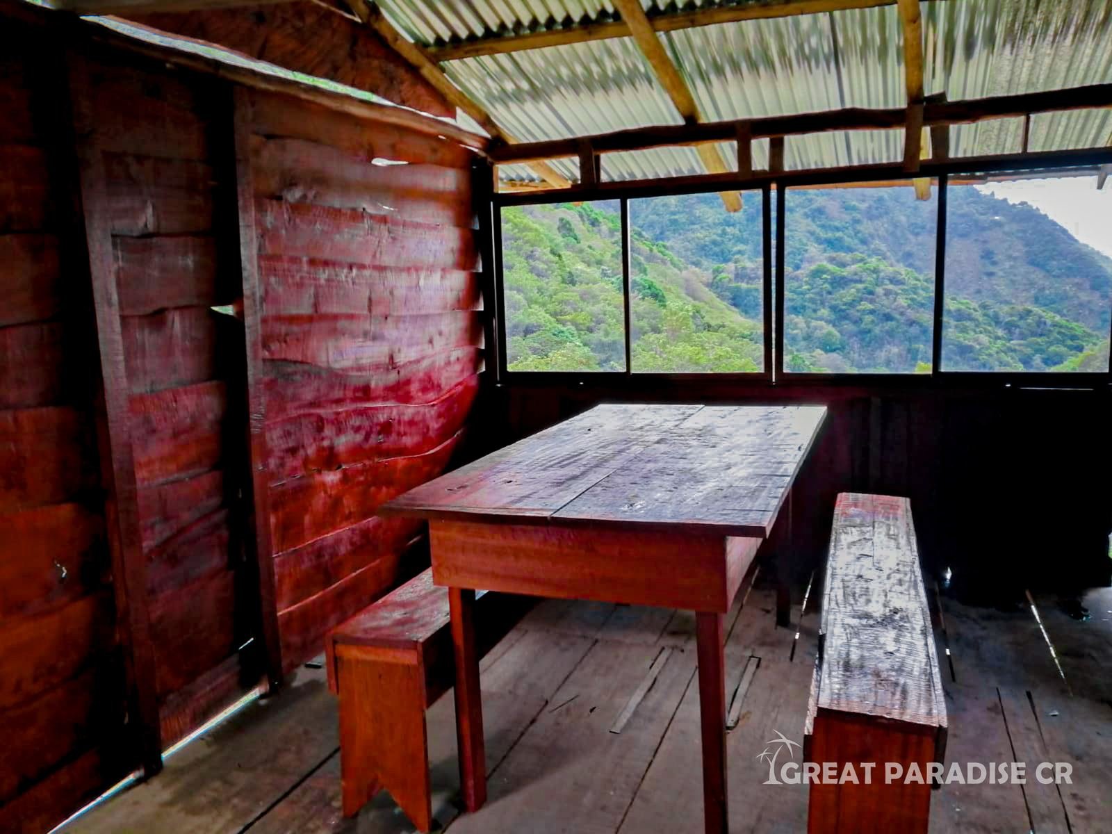 Mesa y ventanas en el interior de la cabaña de Las Catalinas
