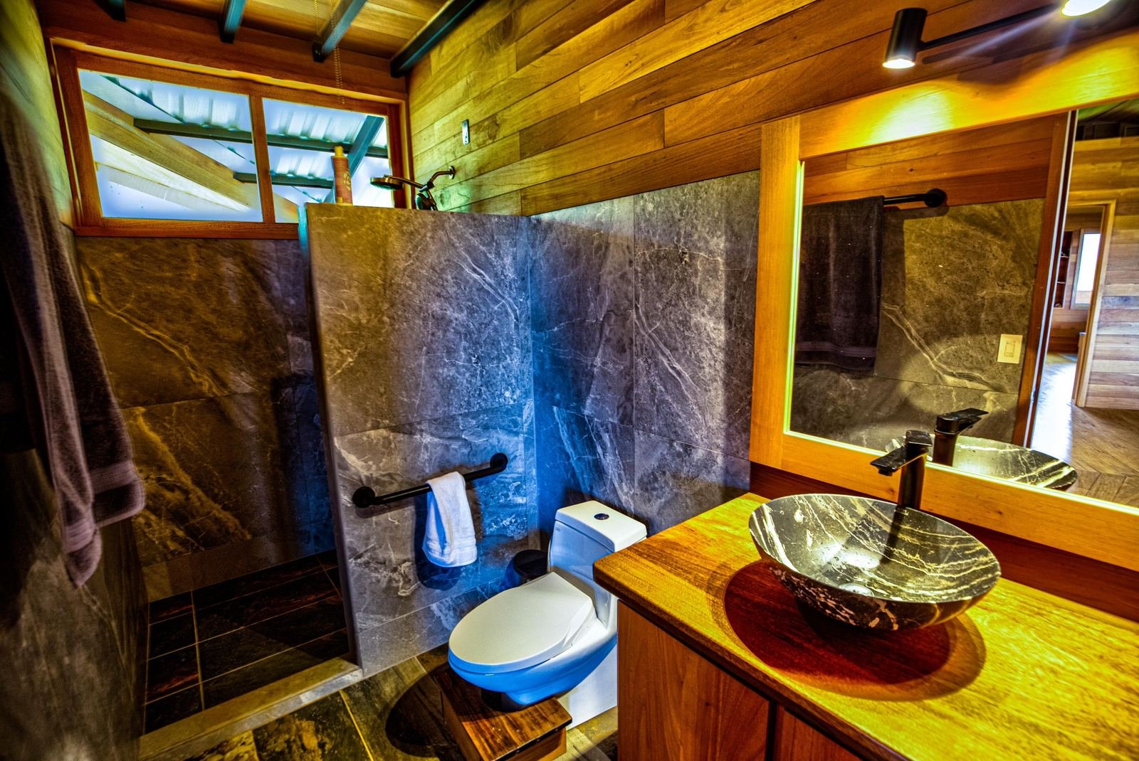 Baño con acabados de madera y lavamanos en Cascada Verde